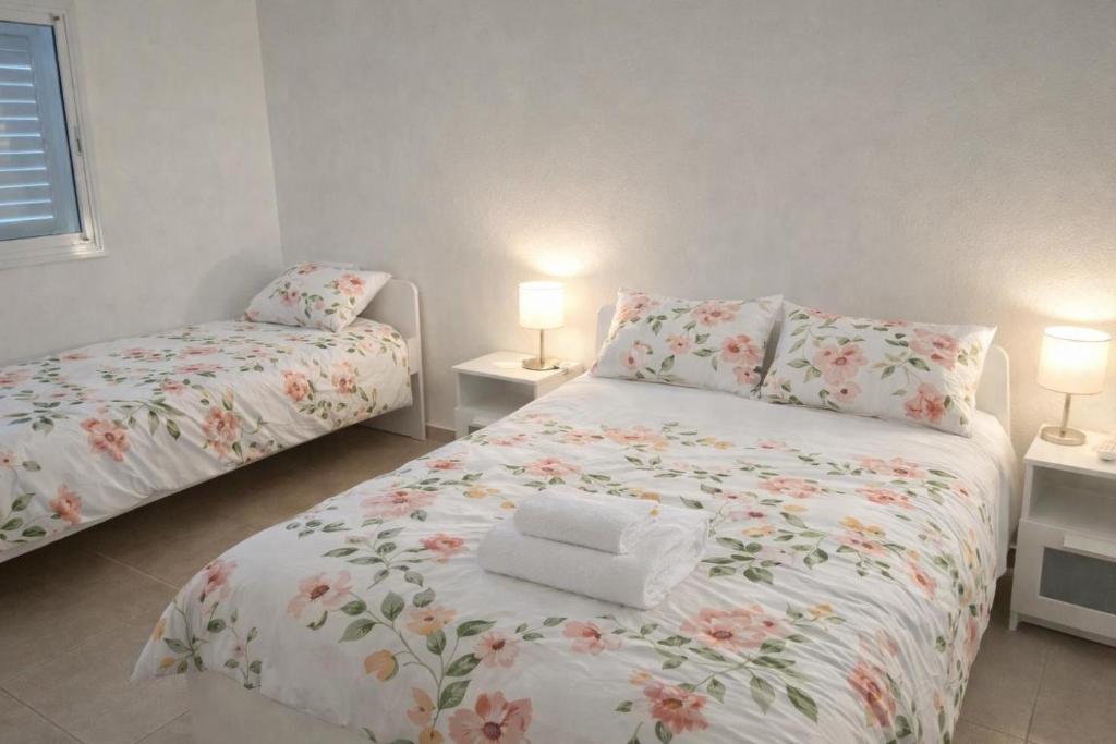 a bedroom with two beds and two lamps at R suite delux in Netanya