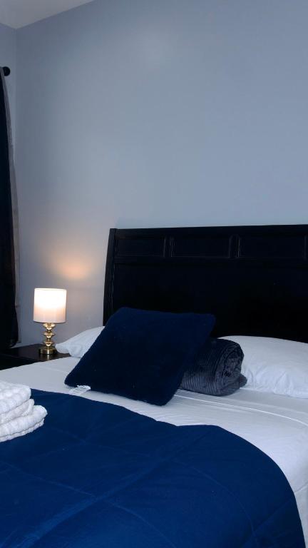 a bed with a blue blanket and a black headboard at New York private room 31 in West New York