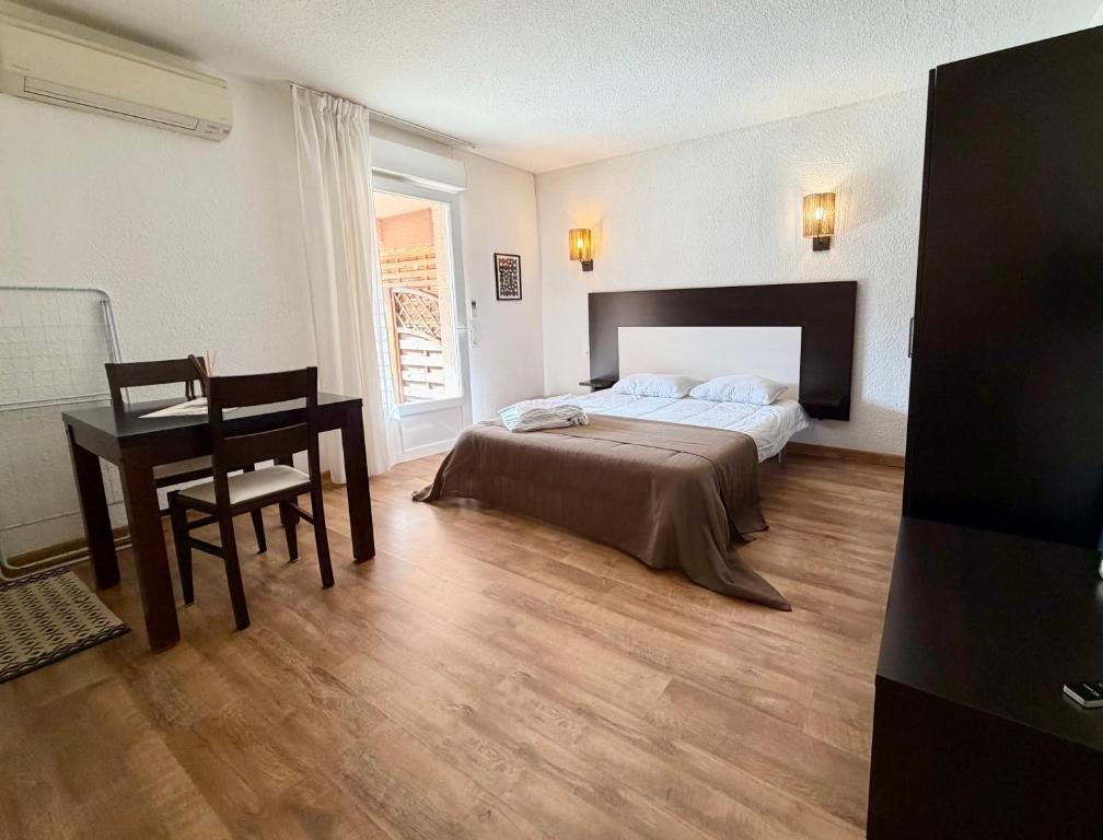 a bedroom with a bed and a table and a desk at SAINT-FLORENT Studio PISCINE FLO300-146 in Saint-Florent