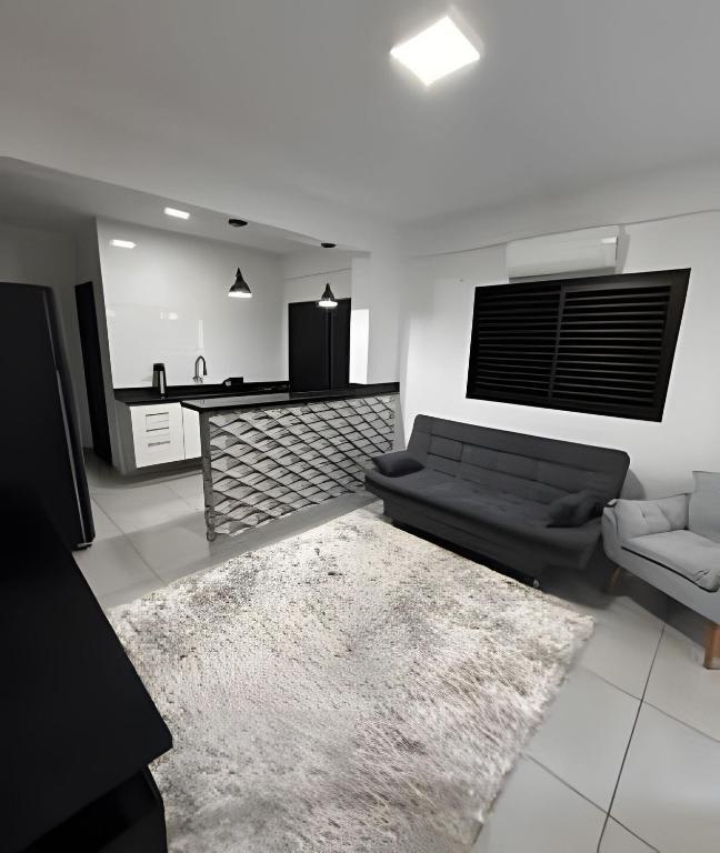 a living room with a couch and a table at Quitinete inteligente Centro da Cidade Unidade 1 in Presidente Prudente