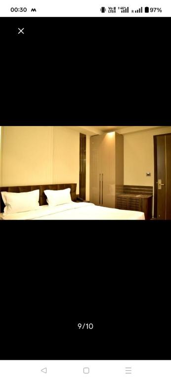 a hotel room with a bed with white pillows at HotAlnovaiN in Agra