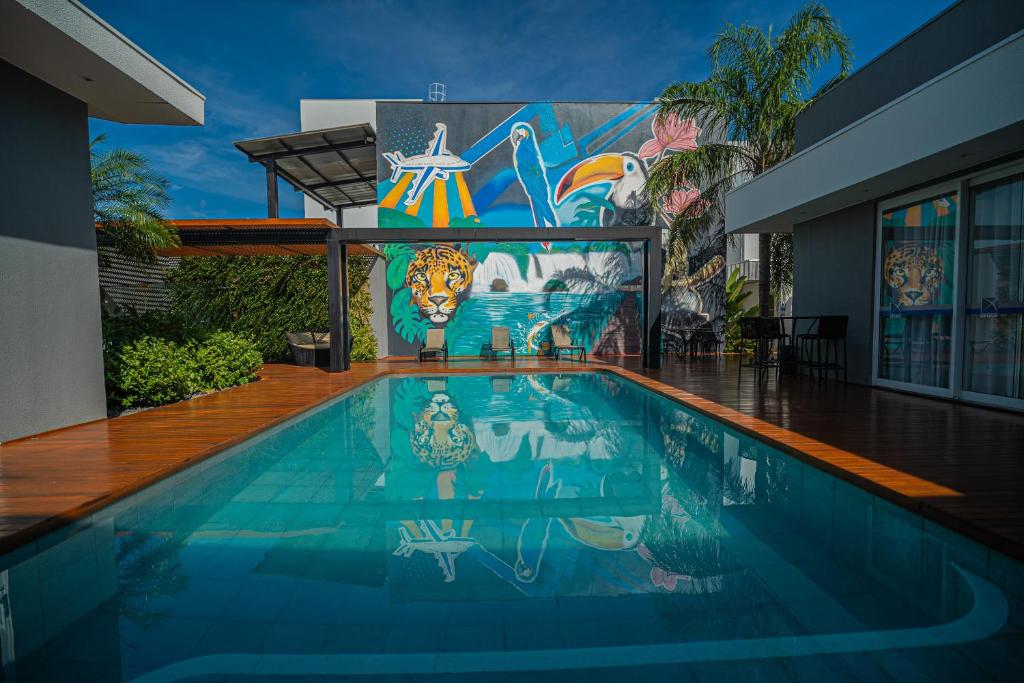 a swimming pool with a mural on the side of a building at Hotel Opuka in Sorriso