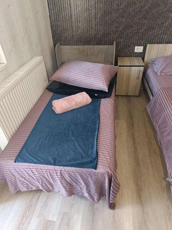 two beds in a room with purple sheets at Magda in Constanţa