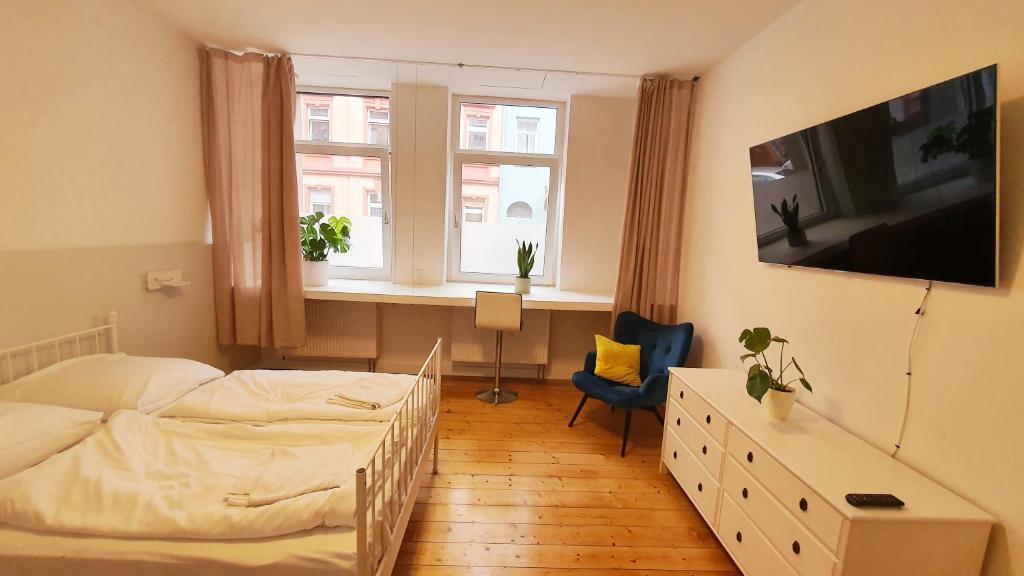 a bedroom with a bed and a desk and two windows at Zimmer im Erdgeschoss in Mannheim