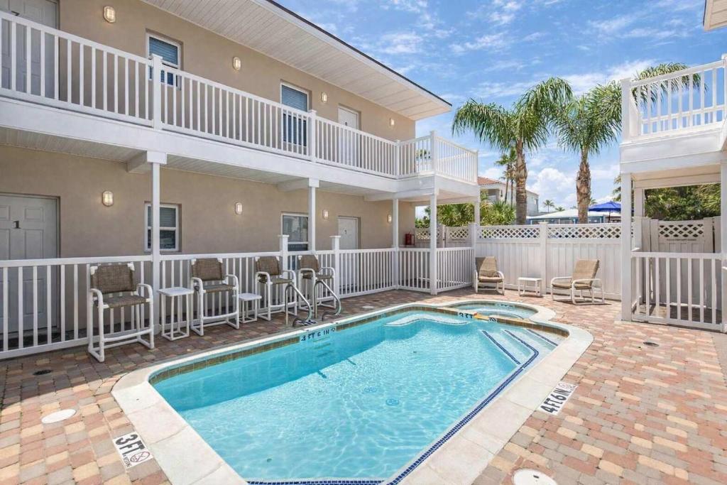 a villa with a swimming pool and a house at Los Cabos I #5 condo in South Padre Island