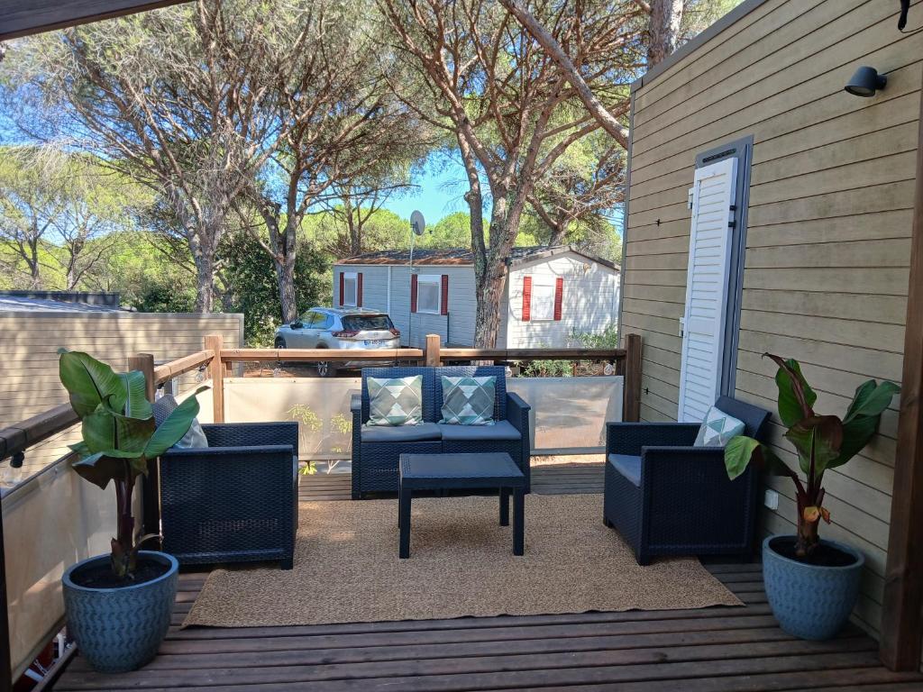 een terras met stoelen en een tafel op een vlonder bij Camping in Le Muy