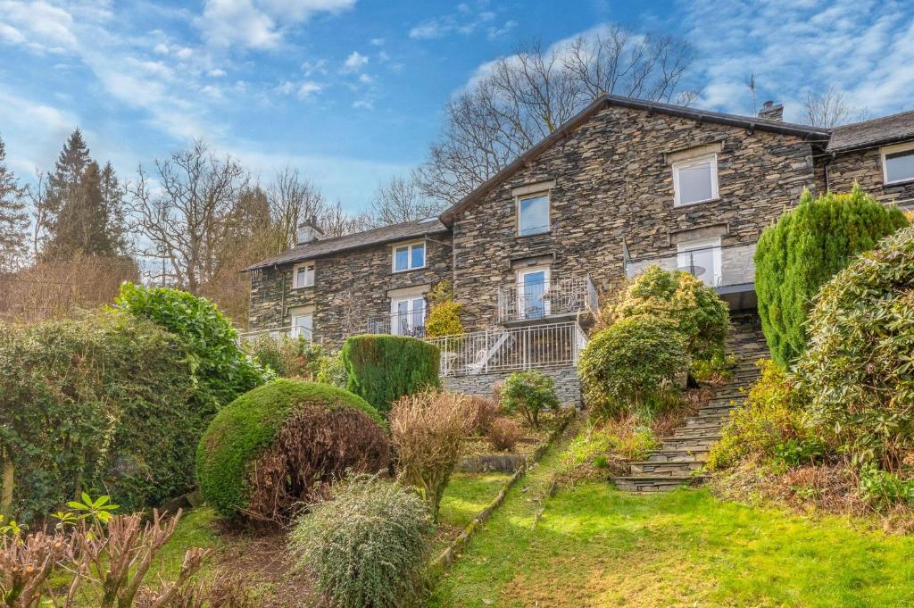 a stone house with a garden in front of it at Tanderra Coniston in Coniston