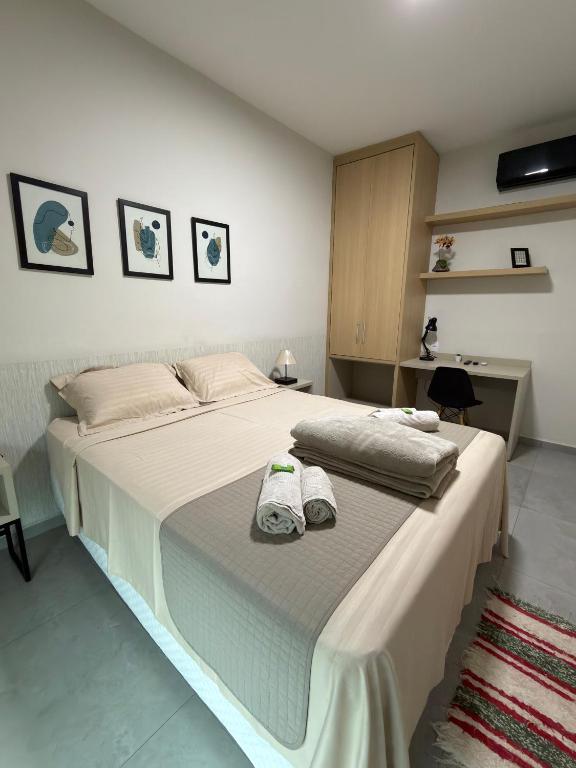 a bedroom with a large bed with towels on it at Apartamento Completo localizado no centro in Matias Barbosa