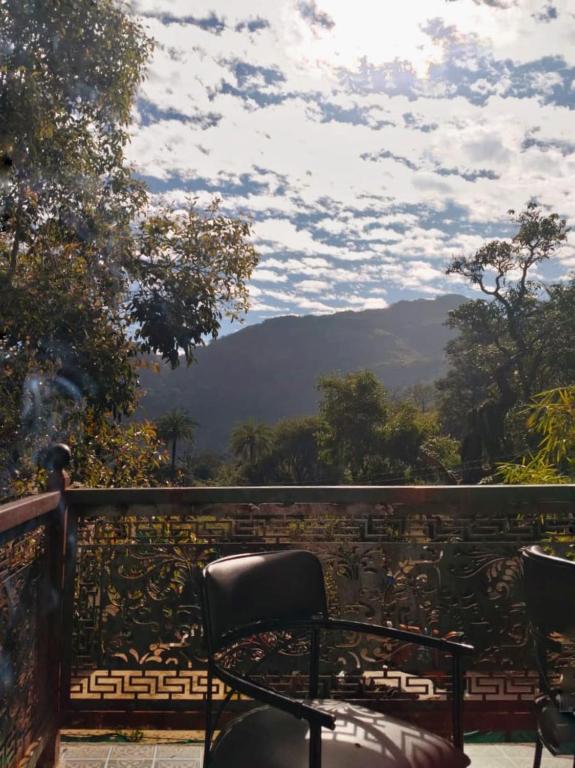 a chair on a balcony with a view of a mountain at Perth villa in Mount Ābu