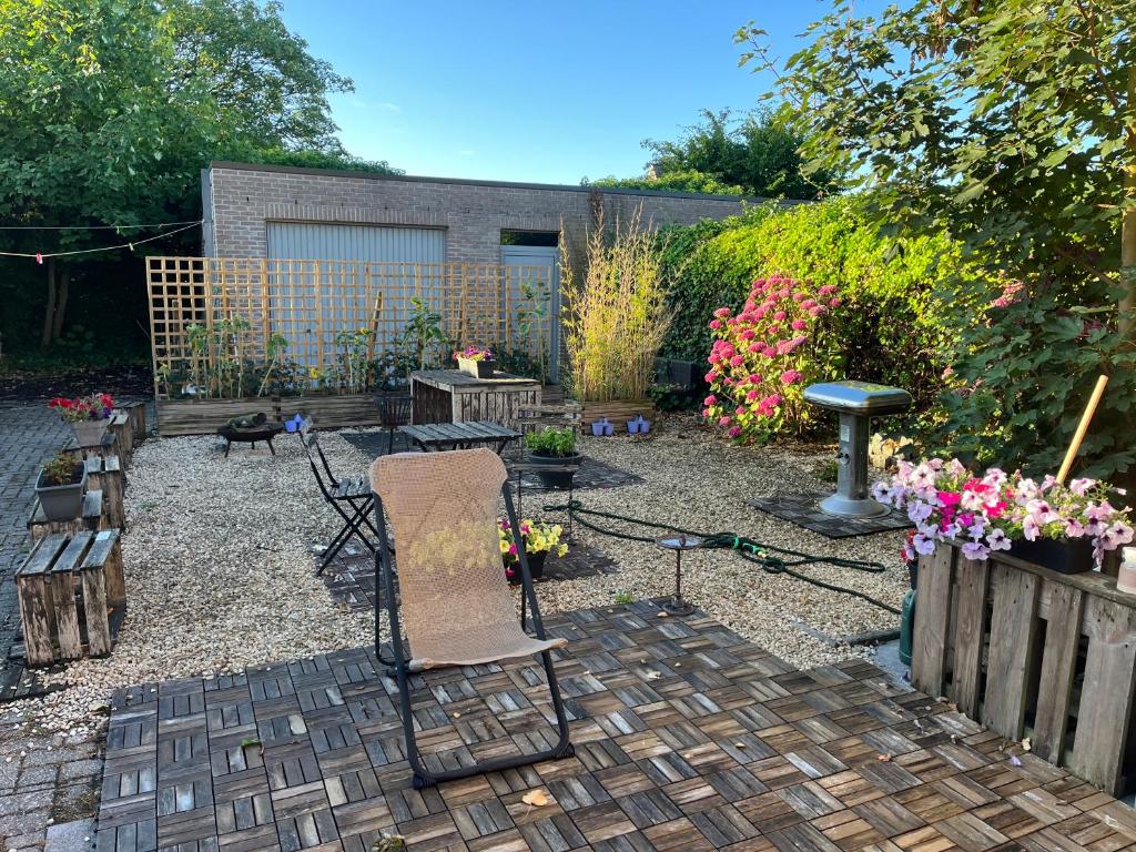 a garden with two chairs and a table and flowers at Casa Leopardo in Hasselt