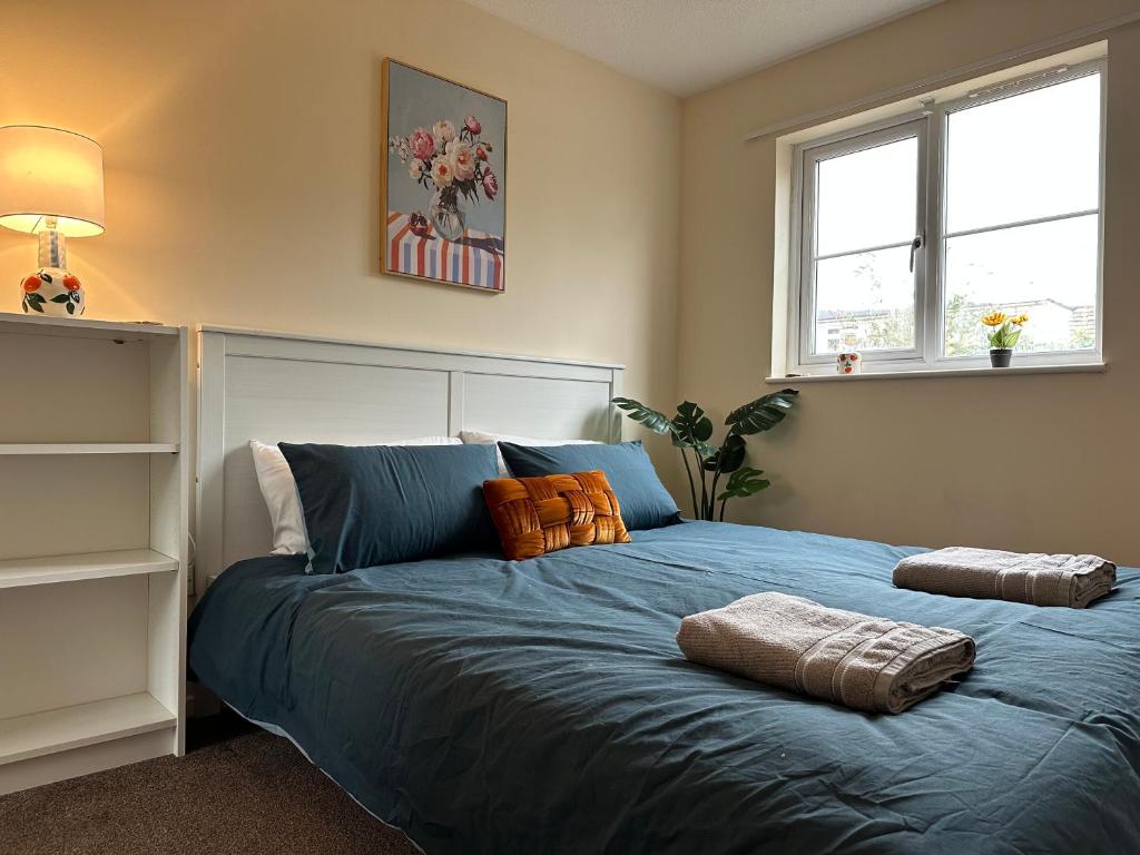 a bedroom with a blue bed with two pillows on it at The Garden Haven in Cheddar