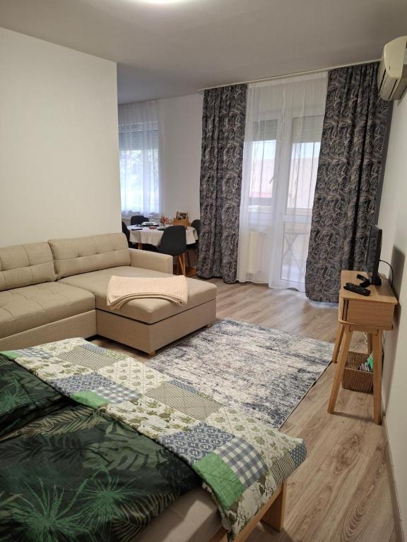 a living room with a couch and a table at GINGER apartman in Hajdúszoboszló