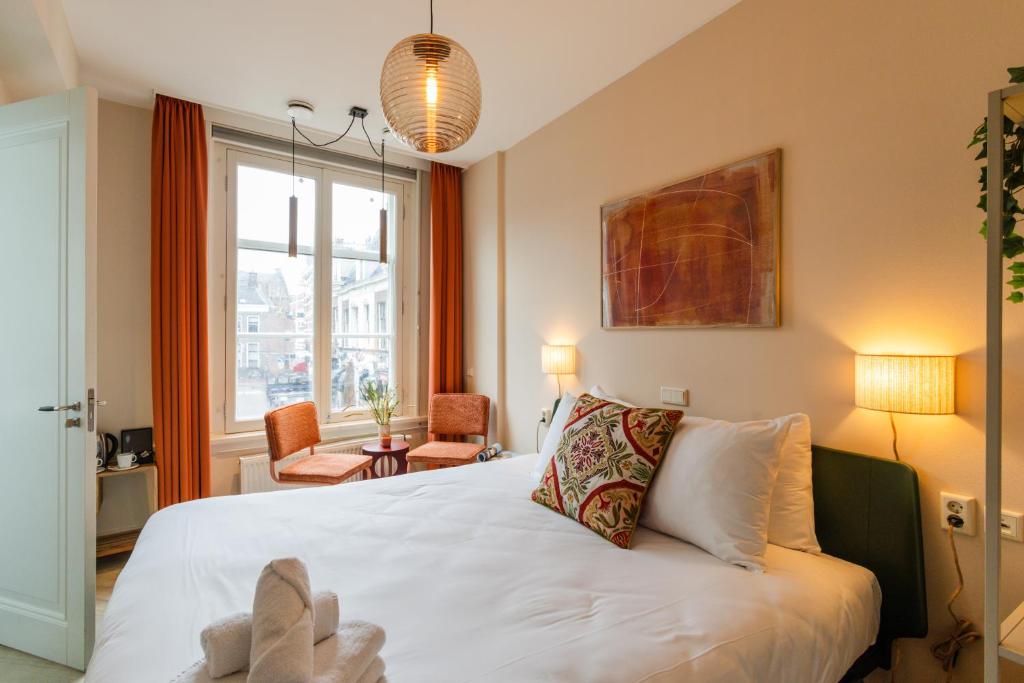 a bedroom with a bed with a stuffed animal on it at Brass Hotel in Utrecht