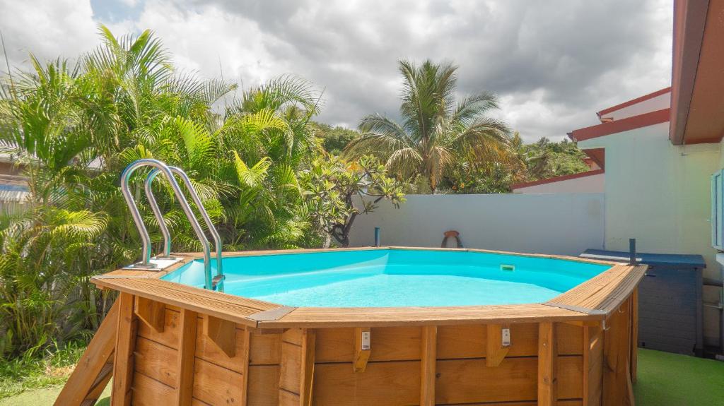 a hot tub on a patio with palm trees at Les Cannes Trankil in Saint-Louis