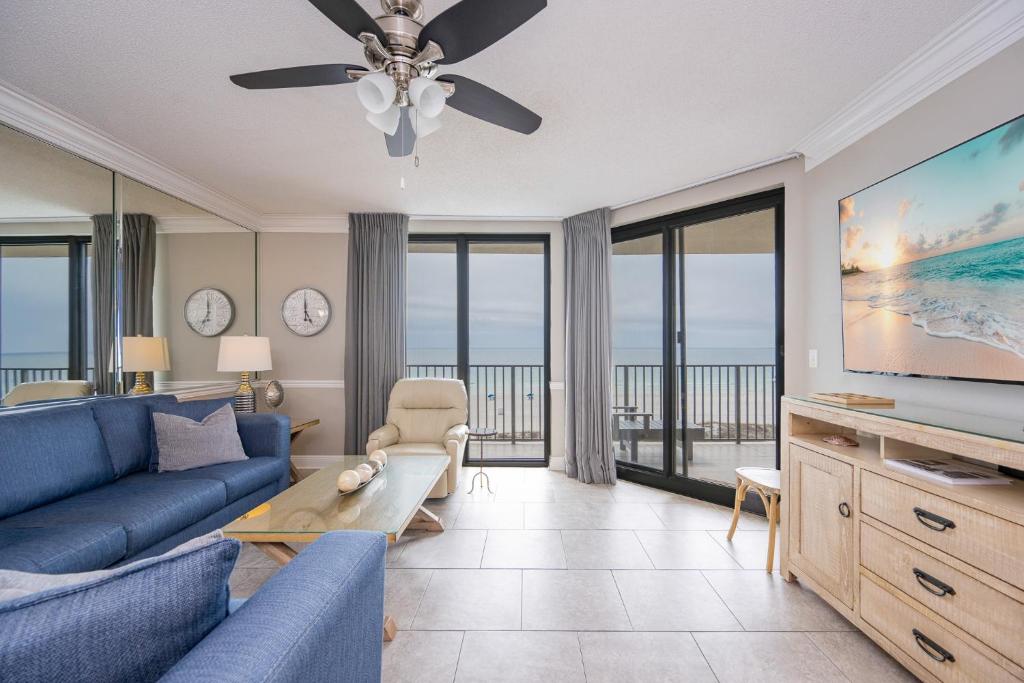 a living room with a blue couch and a flat screen tv at Phoenix X 506 condo in Orange Beach