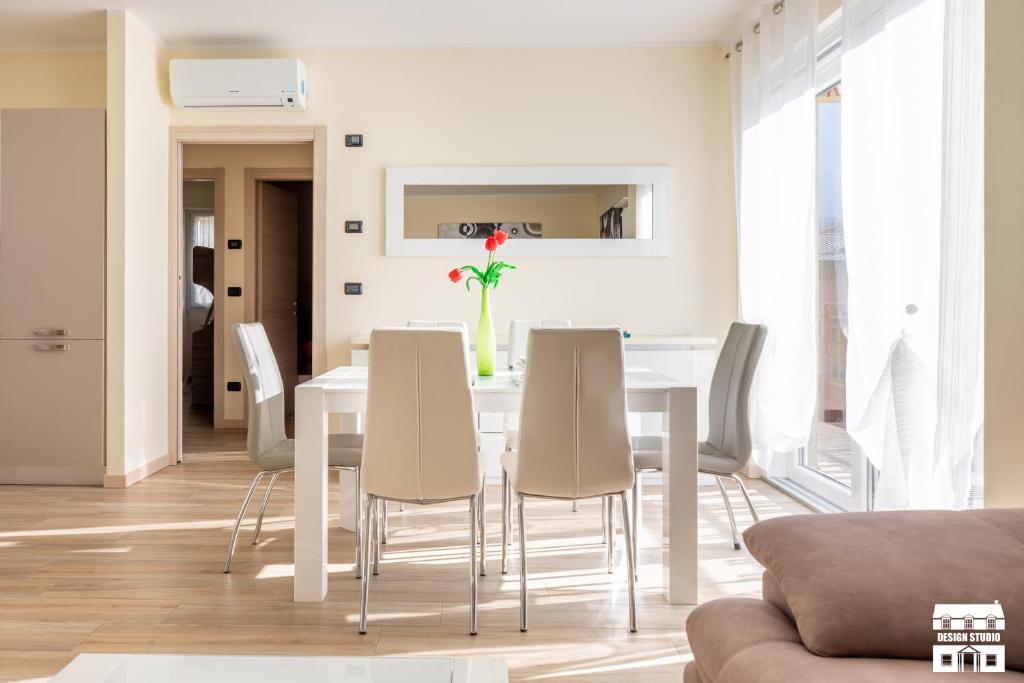 a white dining room with a white table and chairs at CASA MIA by Design Studio in Colico