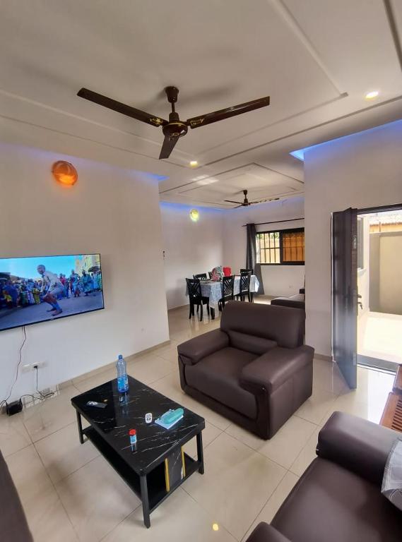 a living room with a couch and a table at Villa Moderne 4 Chambres avec Suite in Loué