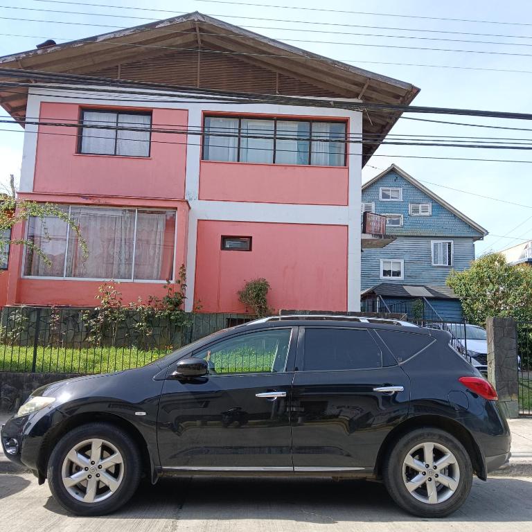 a black car parked in front of a house at Hostal Adriana in Valdivia