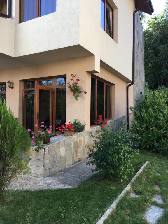 a house with flowers on the side of it at The Lake Villa in Smolyan