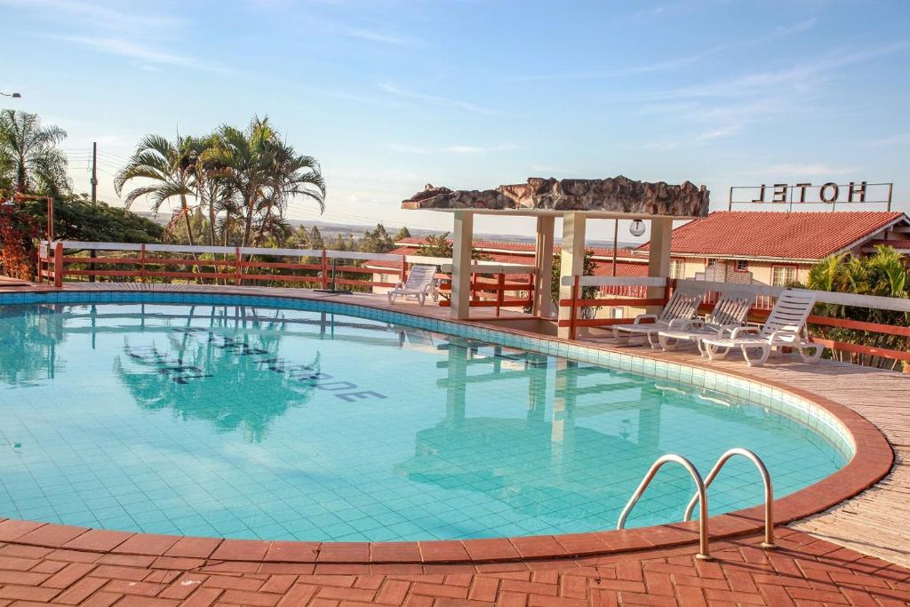 a large swimming pool in a resort with chairs at Hotel Serra Verde in Rio Verde de Mato Grosso