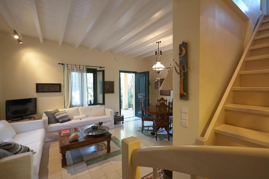 a living room with a white couch and a staircase at Anassa Boutique Beach House in Sami