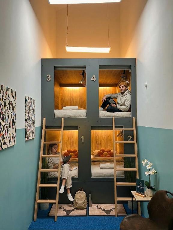 a bunk bed in a room with two people in it at UrbanKey Pods - Vienna Neubau in Vienna
