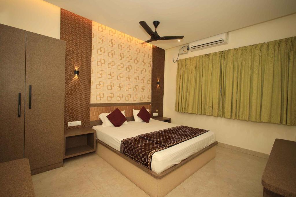 a bedroom with a bed and a ceiling fan at Thendral inn in Vellore