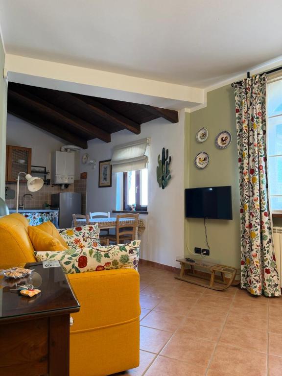 a living room with a yellow couch and a table at La Corte di San Rocco in Murazzano