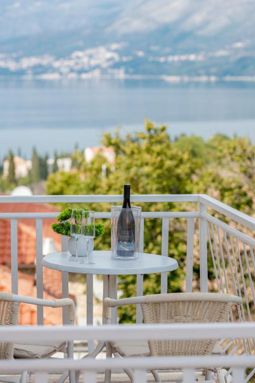 a table with a bottle of wine on a balcony at Cozy Corner 49 in Cavtat