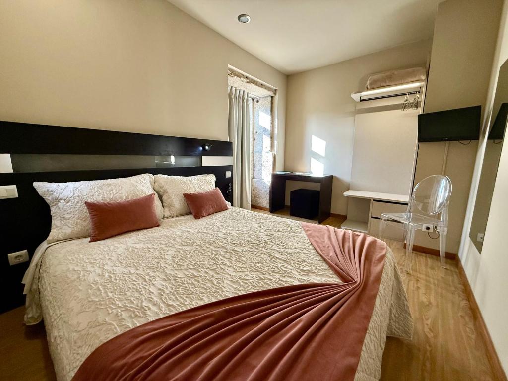 a bedroom with a large bed with red pillows at Residencial Portas do Sol in Valença