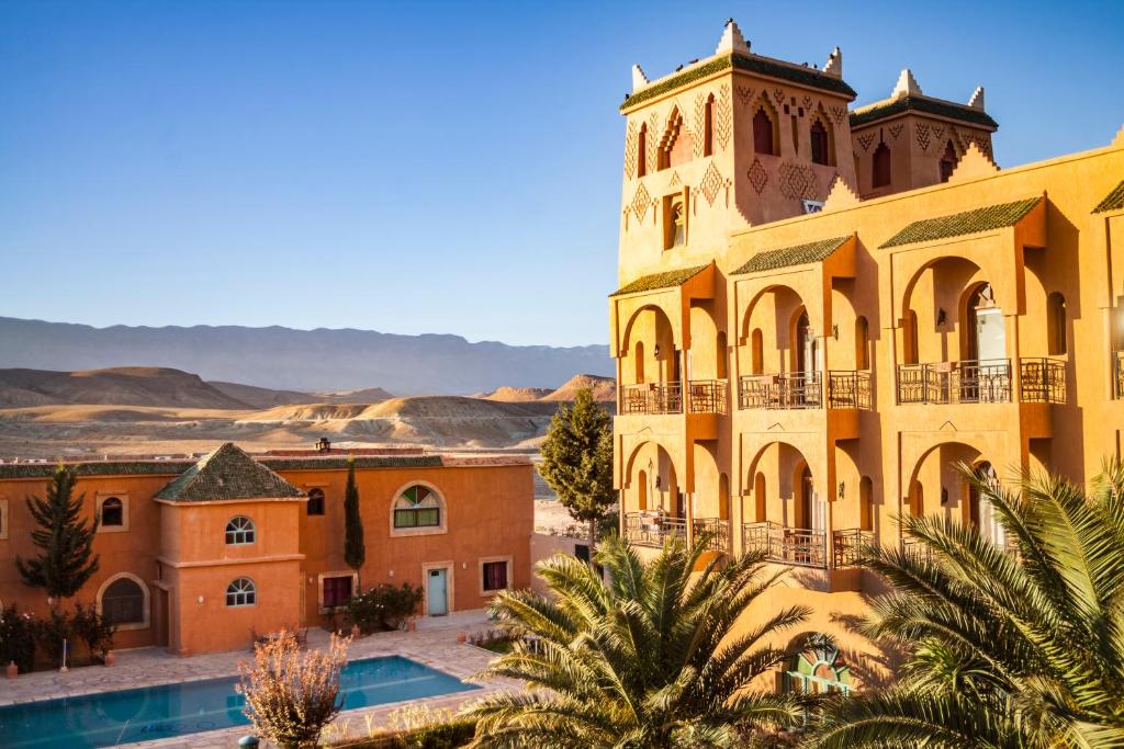 un grand bâtiment jaune avec une tour d'horloge dans l'établissement Hotel Kasbah Asmaa, à Midelt