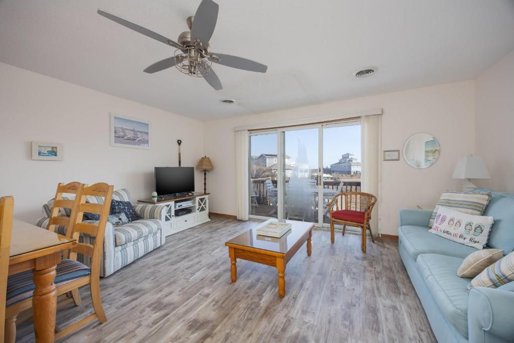 a living room with a blue couch and a tv at 4208 - Naan Sands in Duck