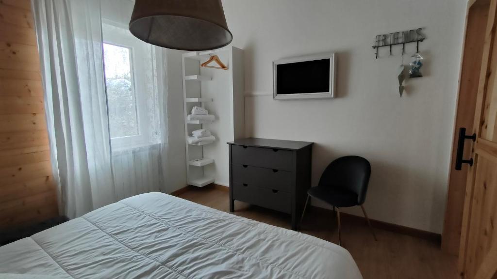 a bedroom with a bed and a chair and a television at Piccolo Appartamento Casa Vacanze B&B Angela in Clusone