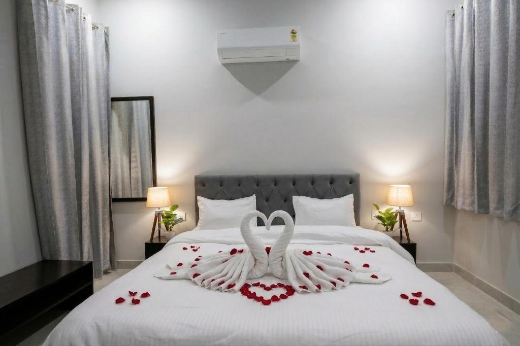 two white swans are forming a heart on a bed at The Stripes Ranthambore in Sawāi Mādhopur
