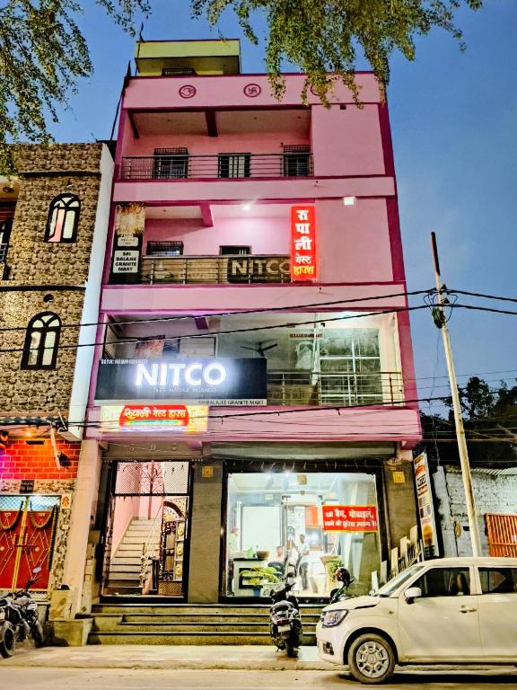 a pink building with a nintendo sign in front of it at Rupali Guest House in Patna
