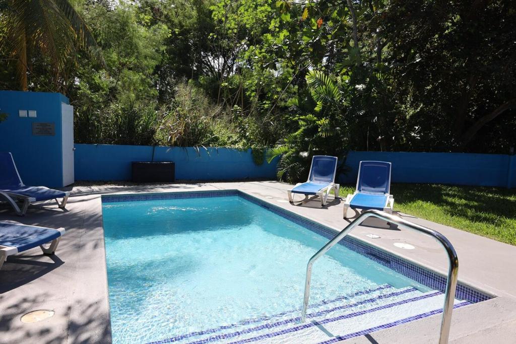 two chairs sitting next to a swimming pool at Villa Blue Nights in Saint James