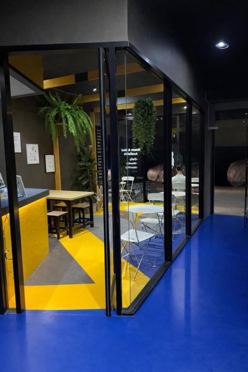 a room with glass doors and a yellow and blue floor at Free Way Kata Beach Hostel in Kata Beach