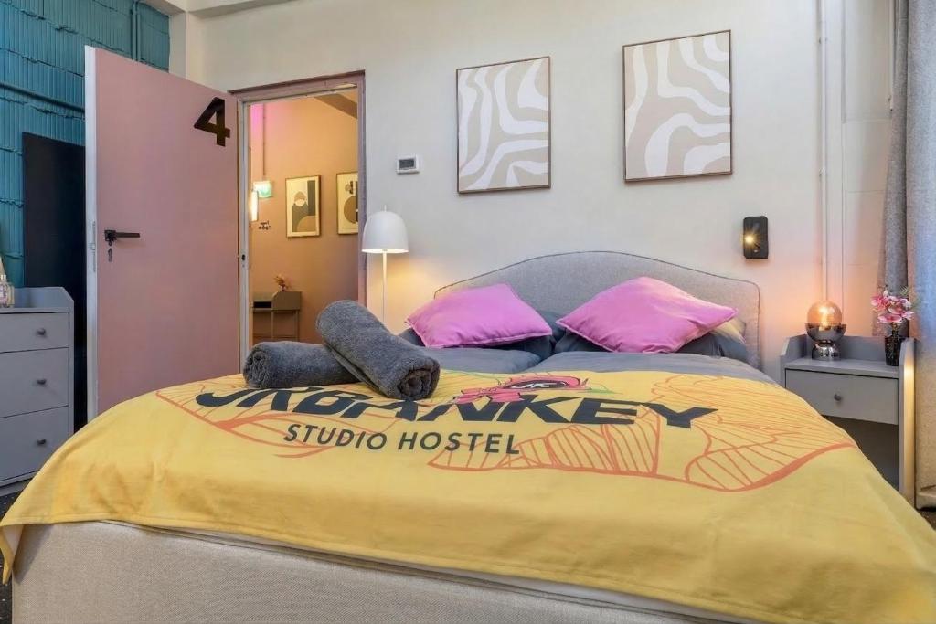 a bedroom with a large bed with pink and yellow sheets at UrbanKey Studios - Vienna Mitte in Vienna