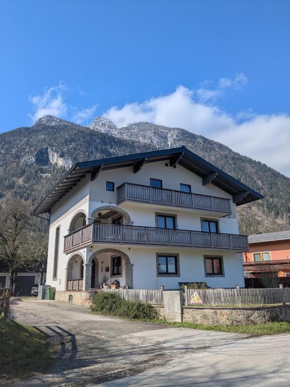 a large white house with mountains in the background at Apartment L i e b l i n g s o r t in Golling an der Salzach