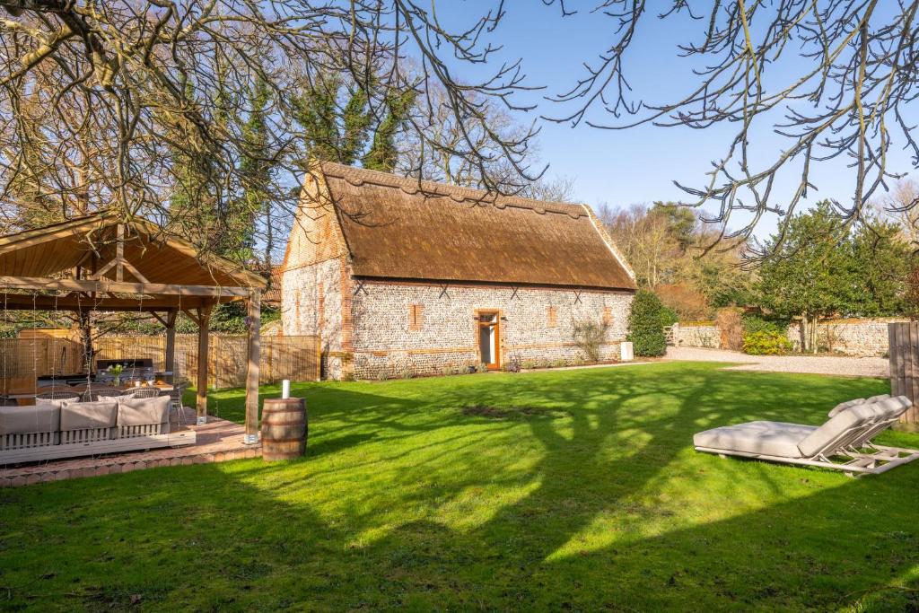 a large yard with a stone building with a roof at Hillside Barn in Gimingham