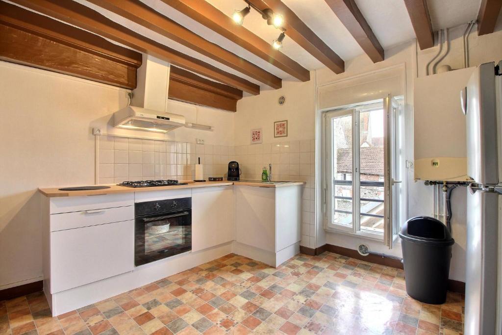 a kitchen with white cabinets and a stove top oven at Le Franche in Châtillon-sur-Loire
