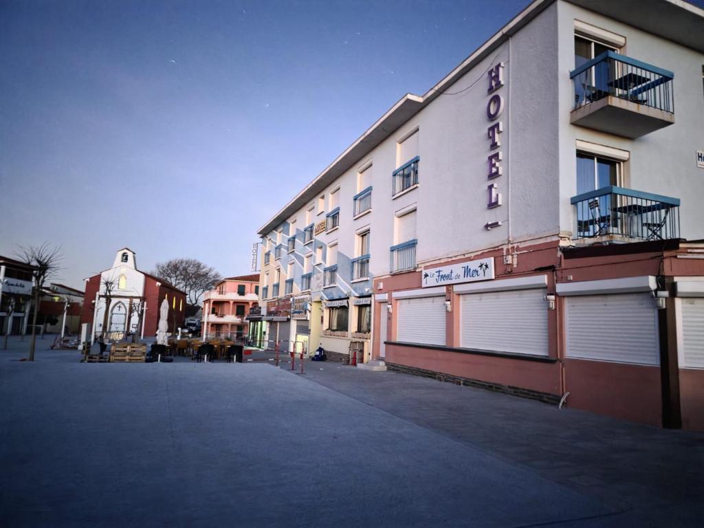 a white building with a sign on the side of it at Hotel de la Plage - Barcares in Le Barcarès