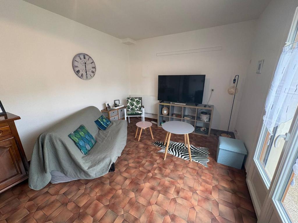 a living room with a couch and a clock on the wall at Le Nevoy in Nevoy