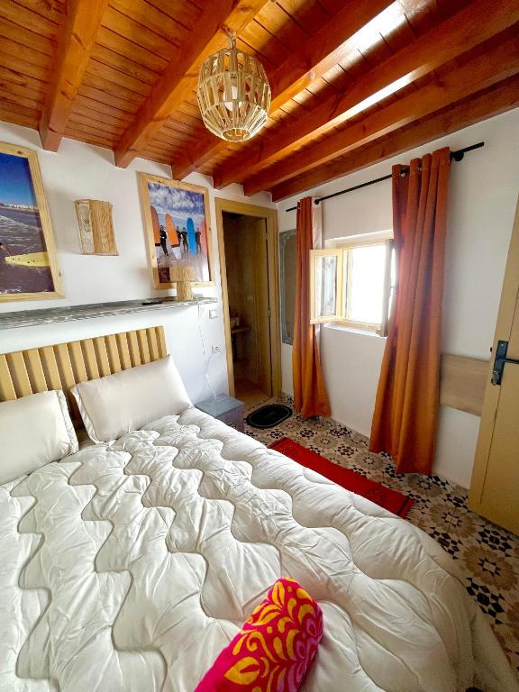 a bedroom with a large bed and a chandelier at Surf house in Essaouira