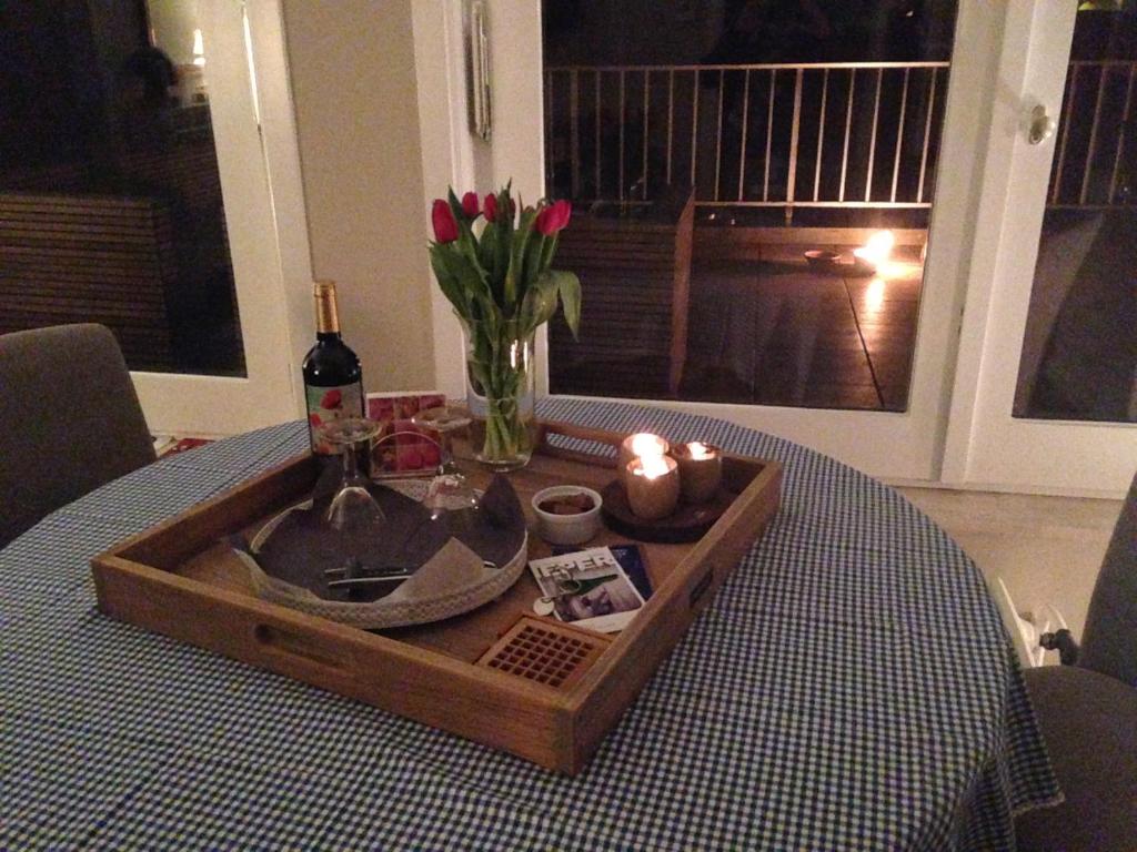 una mesa con una bandeja con velas y una botella de vino en Atrium, en Ypres