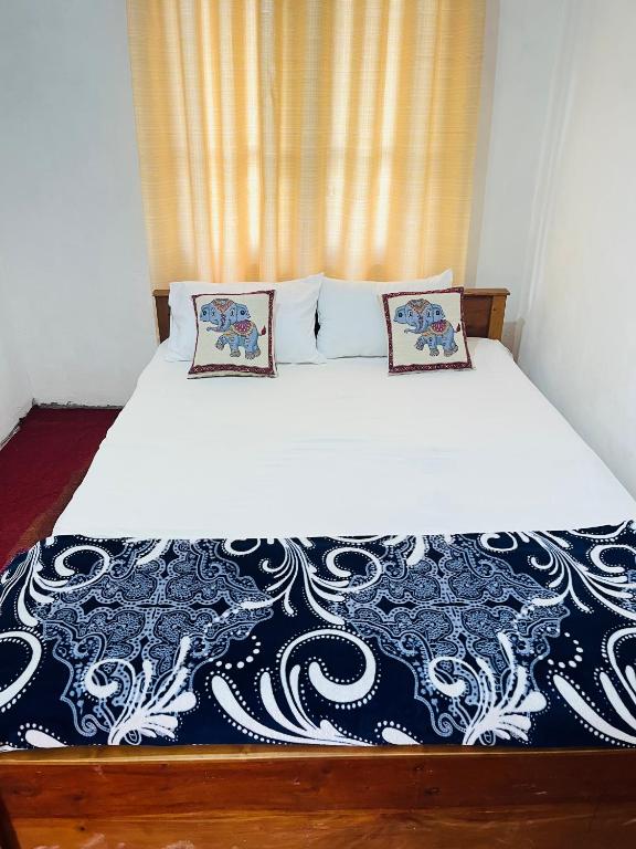 a bed with two pillows on it in a room at Cinderella three arch view in Ella
