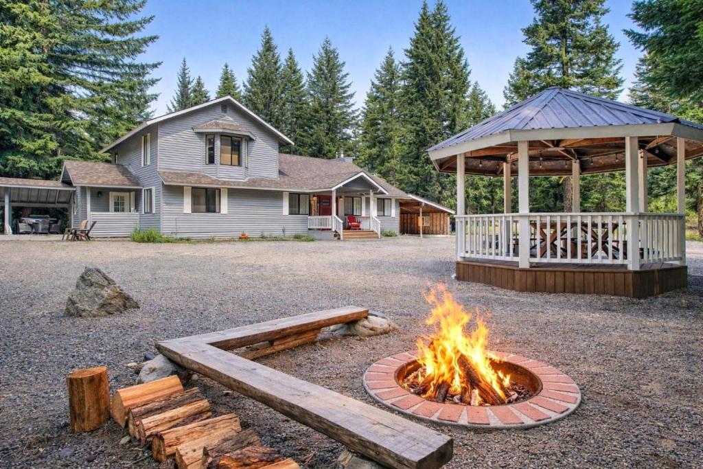 a fire pit in front of a house with a gazebo at Driftwood in Ronald