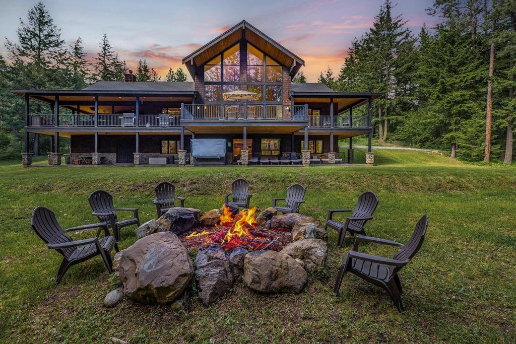 a large house with a fire pit in front of it at Grand Manifest Lodge in Ronald