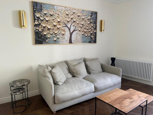 a white couch in a living room with a picture on the wall at Hyper centre st Germain en laye appt de standing in Saint-Germain-en-Laye