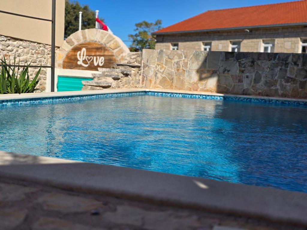 a swimming pool with a waterfall in front of a building at Holiday house with a swimming pool - Villa Melavita in Stari Grad